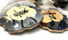 Load image into Gallery viewer, Geode Shaped Coaster with Chinese Characters in White, Black, and Gold.  Love, Goodwill, Peace, and Joy
